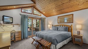 A bedroom with a large bed, a desk, a TV, and a view of the outdoors. - Martis Valley Vistas: Family Home w/ Private Hot Tub, 2 Living Rooms, near Golf (Truckee)