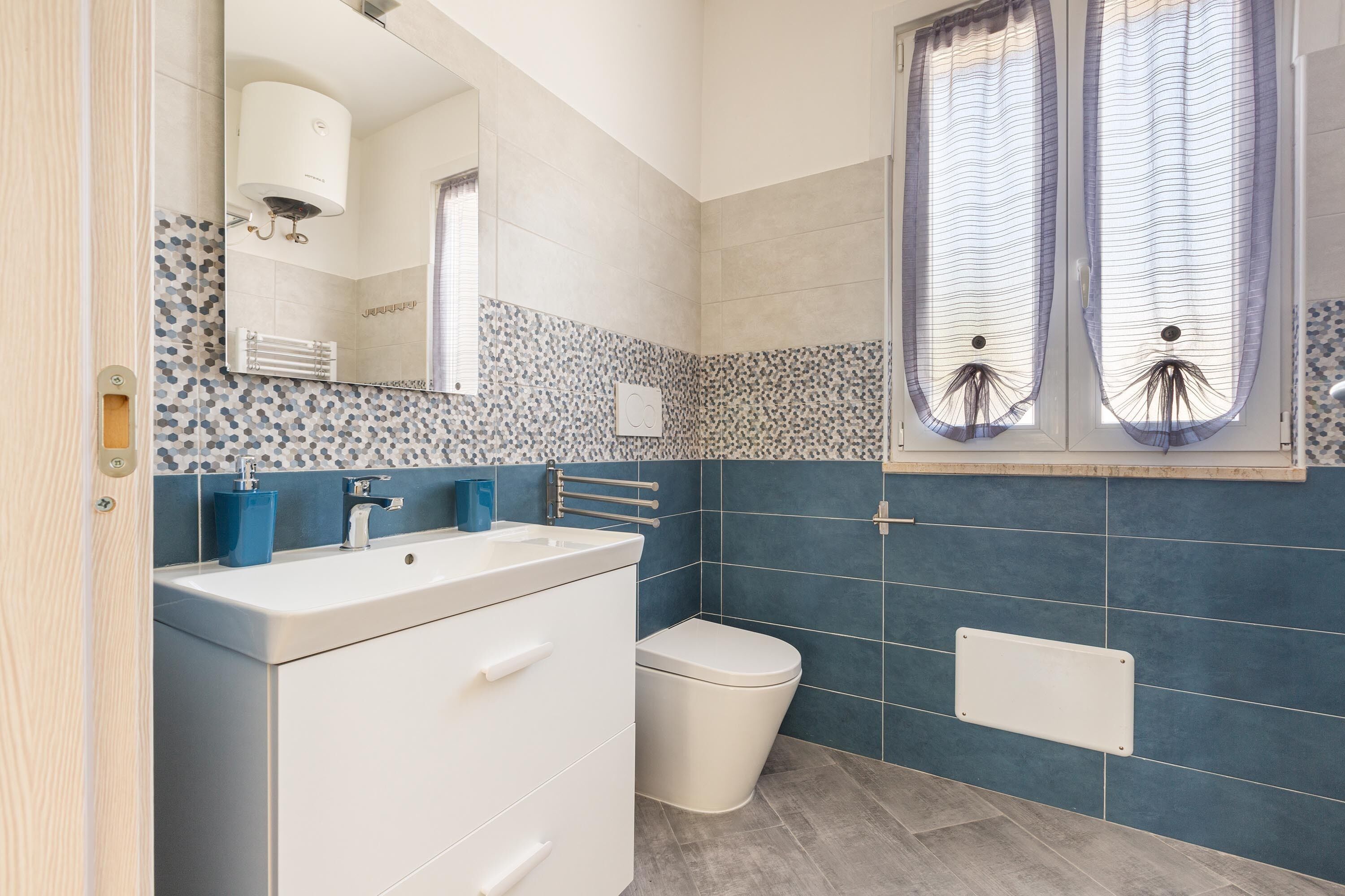 A bathroom with a white sink, a toilet, and a mirror.