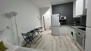 A compact kitchen with a refrigerator, microwave, and washing machine.