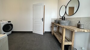 A modern bathroom with a washing machine, a wooden vanity with a sink, and two mirrors. - Former high-capacity factory in the heart of Chagny (Chagny)