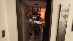 A narrow hallway leading to a dining area with a table and chairs. - AI guest card incl., New, very cozy FEWO comfortable 1A hygiene concept,  (Georgenthal/Thüringer Wald)