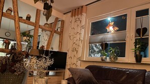 A cozy living room with a leather sofa, wooden decor, and various plants. - AI guest card incl., New, very cozy FEWO comfortable 1A hygiene concept,  (Georgenthal/Thüringer Wald)