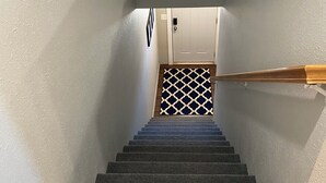 Een beklede trap met houten leuning en een witte deur aan de bovenkant.