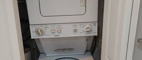 A compact, white, front-loading washing machine with a control panel featuring multiple settings.