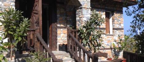 A stone building with a wooden staircase leading to an entrance.