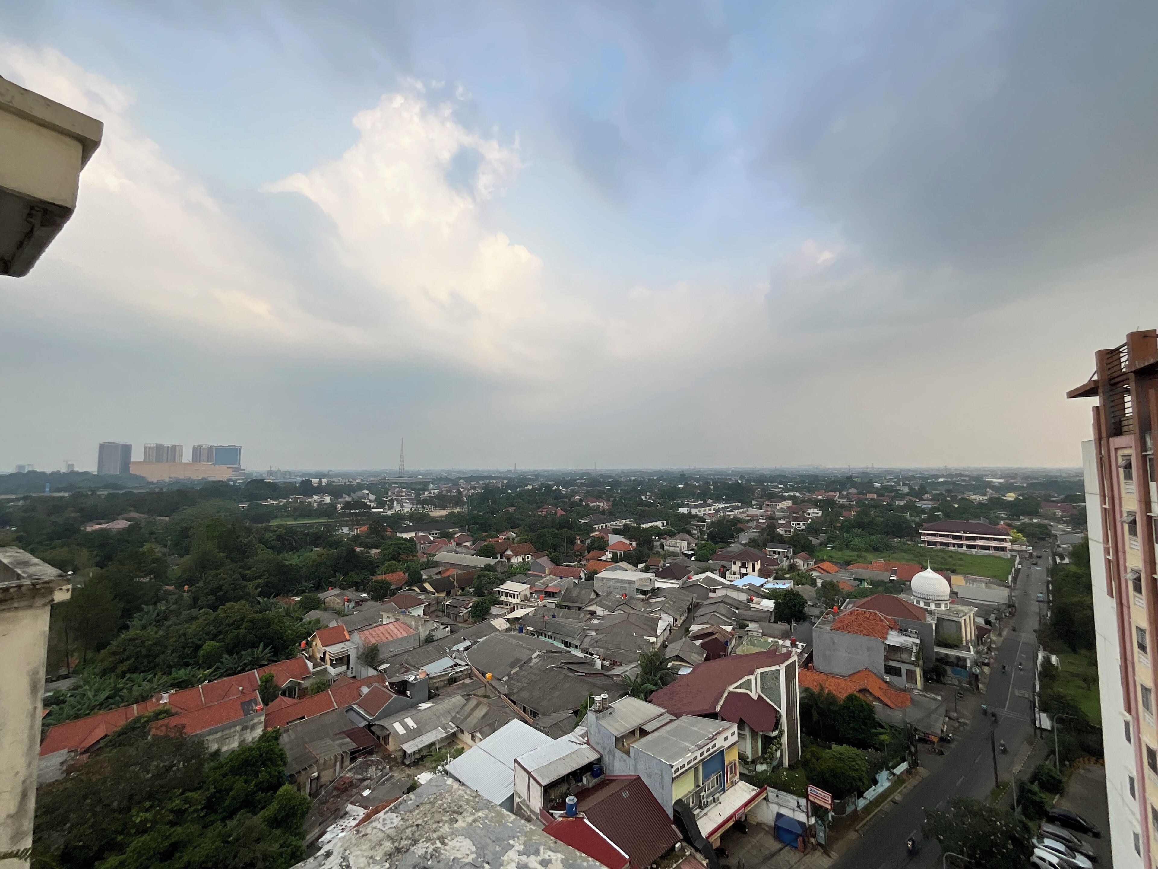 A cityscape with a mix of residential and commercial buildings, a prominent dome-shaped structure, and a distant tower.