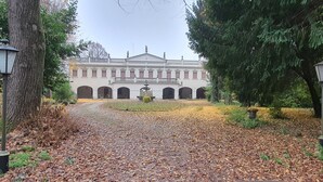 A building with a symmetrical facade, arched windows, and a central fountain.