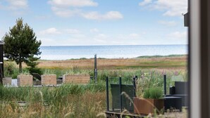 A coastal view with a sandy beach, a wooden structure, and a tree. - Awesome home in ørsted with WiFi (Ørsted)