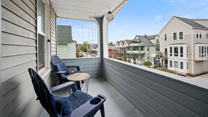 A balcony with two chairs and a small table, overlooking a residential area with houses. - Center of Little Italy #4 (Cleveland)