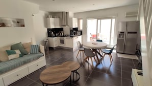 Un apartamento moderno con sala de estar, kitchenette y comedor.