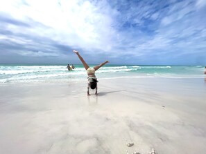 Une scène de plage où une personne fait la verticale.