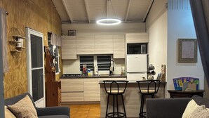 Un espace de vie compact comprenant une cuisine, deux canapés et un coin repas.