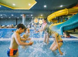 Un área de piscina con varias pistas y un tobogán de agua.