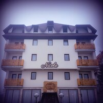 Un hotel de varios pisos con un llamativo letrero que dice "Nicole" en la fachada.