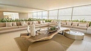 Ein modernes Wohnzimmer mit einer Eckcouch, einem Holztisch und einem runden Glastisch.