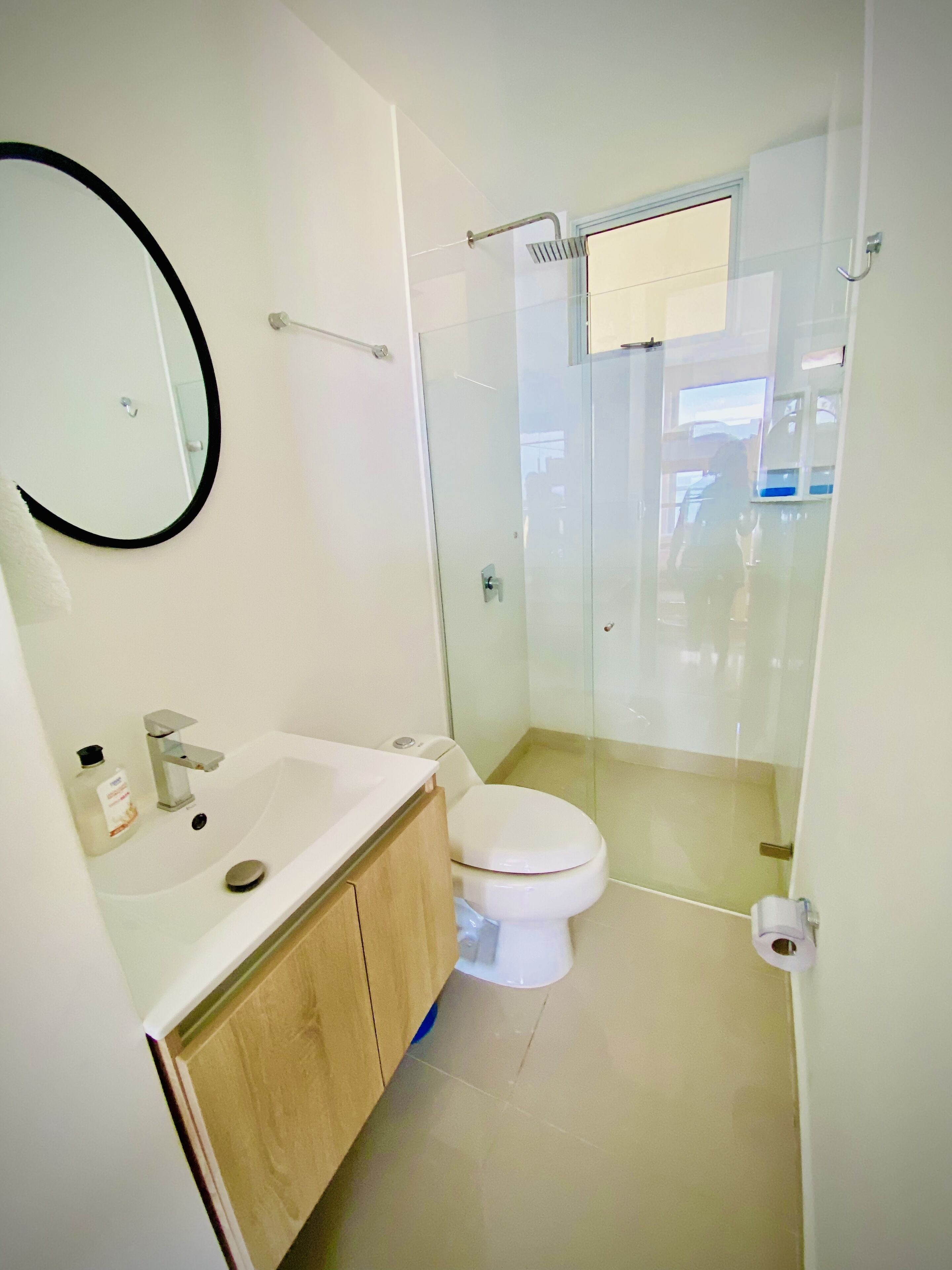 A modern bathroom with a white sink, mirror, and toilet.