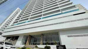 Un moderno edificio de gran altura con una entrada destacada y un letrero que indica que es un hotel.