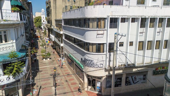 A multi-story hotel with a prominent entrance, large windows, and a visible sign for 'Hotel Casa Libertad'. - Hotel Casa Libertad (Santo Domingo)