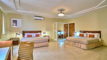 A hotel room with two beds, a desk, a chair, and a sliding door leading to a bathroom.