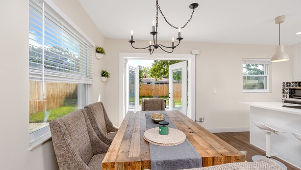 A dining area with a wooden table, woven placemats, and cushioned chairs.