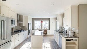 A modern kitchen with white cabinetry, stainless steel appliances, and a central island. - [Egg Farm Ranch] Heated Pool - Water Slide - Hot Tub - Dog Friendly (Kenwood)