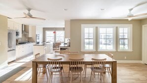 A spacious kitchen with modern appliances, a dining area with wooden chairs, and large windows providing natural light. - [Egg Farm Ranch] Heated Pool - Water Slide - Hot Tub - Dog Friendly (Kenwood)