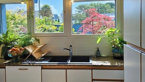 Una cucina con una finestra, un lavandino e un lampadario.