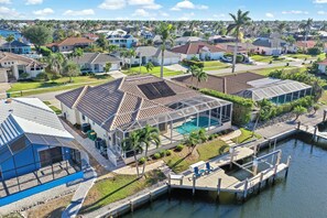 A residential area with houses, a swimming pool, and a dock. - Alluring Waterfront Home | W Exposure, Pool/Dock (Marco Island)