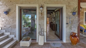 A stone exterior with a glass door and steps leading to a wooden interior. - 3025 Villa Verdeoasi by Barbarhouse (Lecce)