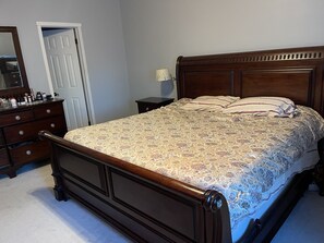 Cozy retreat with a traditional bed, dresser, and nightstand.
