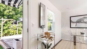 Ein modernes Interieur mit einem Glastisch, einer gerahmten Kunstreproduktion mit Leopardenmuster und einem Metallregal.