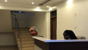 A reception area with a counter, a staircase, and a door.