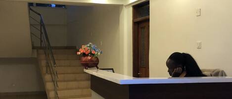 A reception area with a counter, a staircase, and a door.