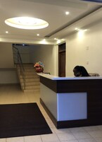 A reception area with a counter, a staircase, and a door.