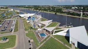Un grand parc aquatique comprenant une piscine, un pont et un parking.