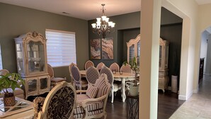 Un comedor con muebles ornamentados, una araña y obras de arte en las paredes.