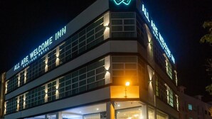 A multi-story hotel with illuminated signage reading "ALL ARE WELCOME INN" and "ALL ARE WELCOME HOTEL". - All Are Welcome Lawas Boutique Hotel (Lawas)