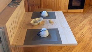 A wooden dining table with two white mugs and a white bowl. - Comfortable alpine-style LA STAFFA hut 5 minutes from Bormio (Valdidentro)