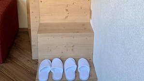 A wooden staircase with three steps, each with a pair of white slippers placed on the bottom step. - Comfortable alpine-style LA STAFFA hut 5 minutes from Bormio (Valdidentro)