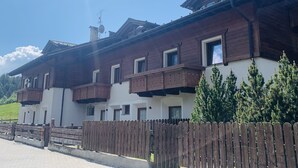 A traditional chalet with wooden balconies, white walls, and a wooden fence. - Comfortable alpine-style LA STAFFA hut 5 minutes from Bormio (Valdidentro)