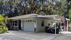 Ett envåningshus med ett garage, en inglasad veranda och en amerikansk flagga.