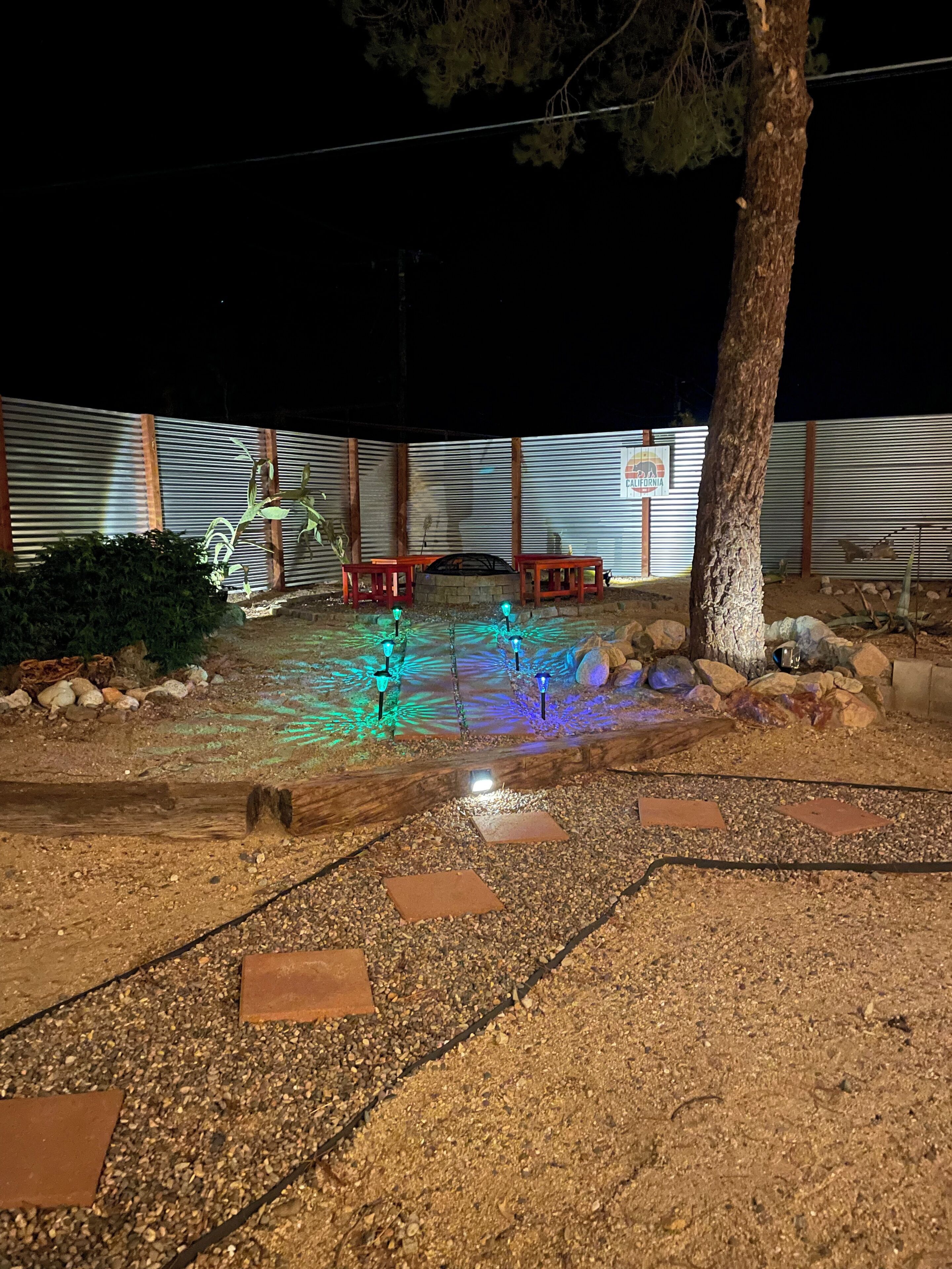 A patio area with a fire pit, seating, and decorative lighting.