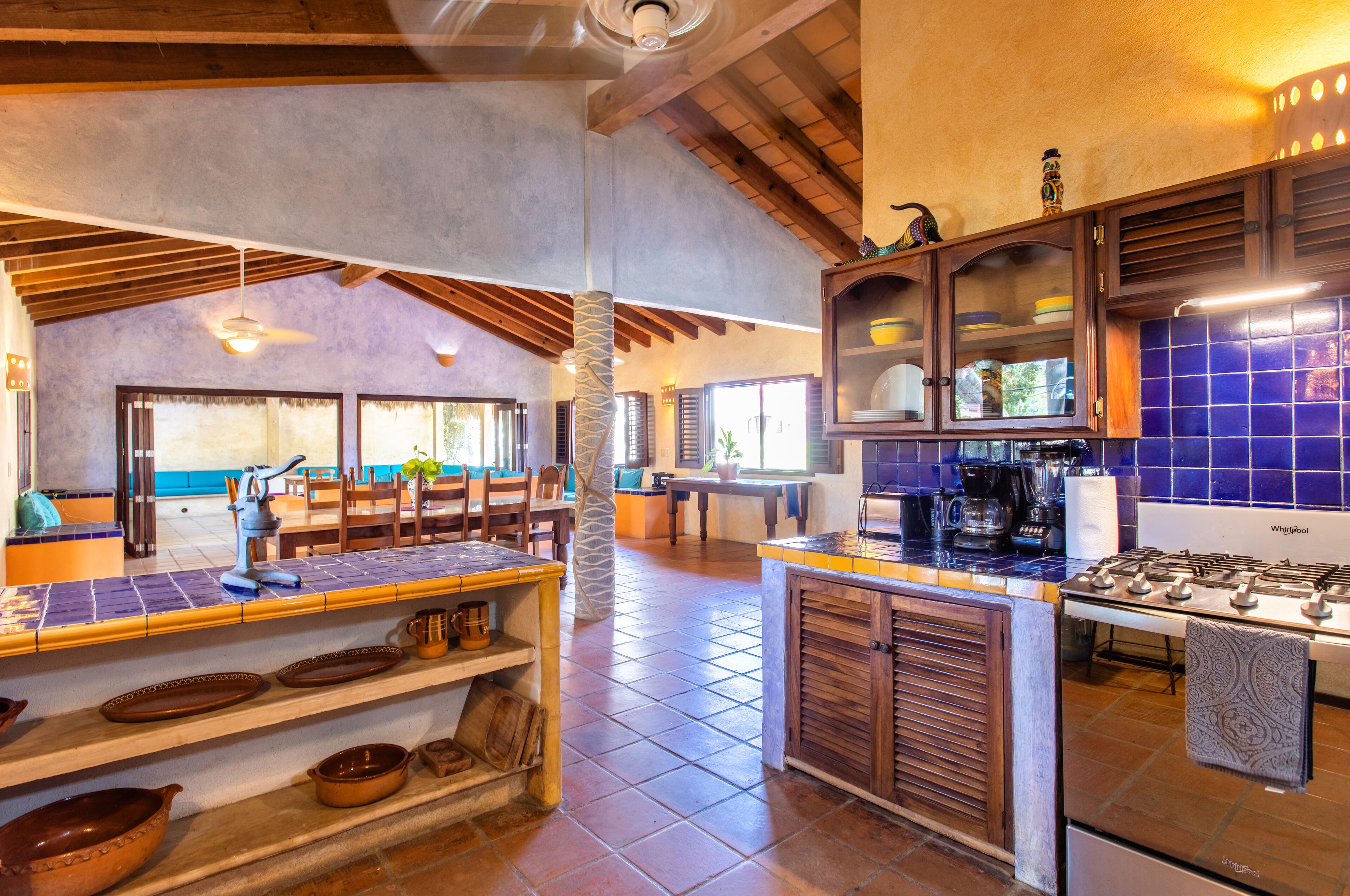 A spacious kitchen with a central island, wooden cabinets, and a dining area with a view.