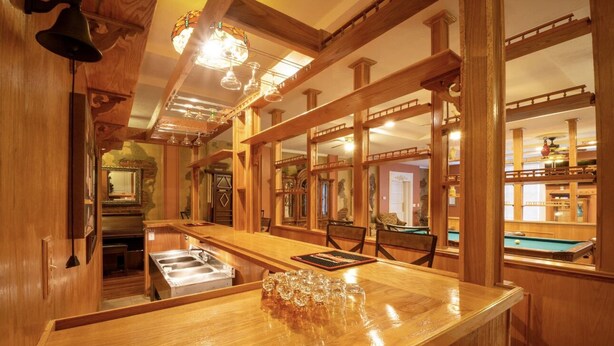 A wooden bar area with a pool table, a mirror, and a sink. - The Hidden Gem in downtown Connersville (Connersville)
