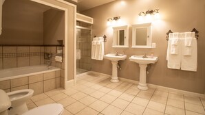 A bathroom with a bathtub, two sinks, a toilet, and a shower. - The Hidden Gem in downtown Connersville (Connersville)