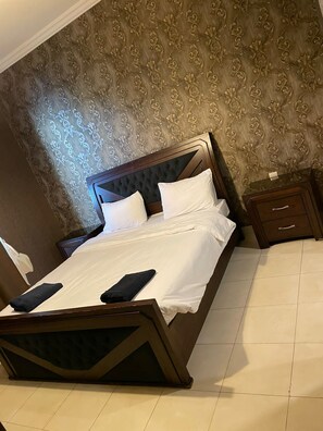 Relax in comfort with a large bed, tufted headboard, and a cozy throw blanket.