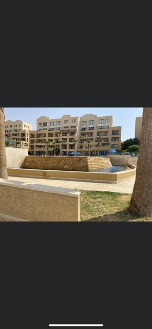 Stunning hotel complex with modern architecture and serene water feature.