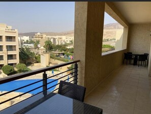 Enjoy dining or relaxing on this balcony overlooking the swimming pool.