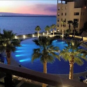 Relax by the pool surrounded by palm trees and enjoy the serene atmosphere.