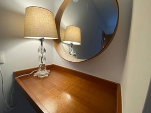 Features a vanity table with a crystal lamp and round mirror.